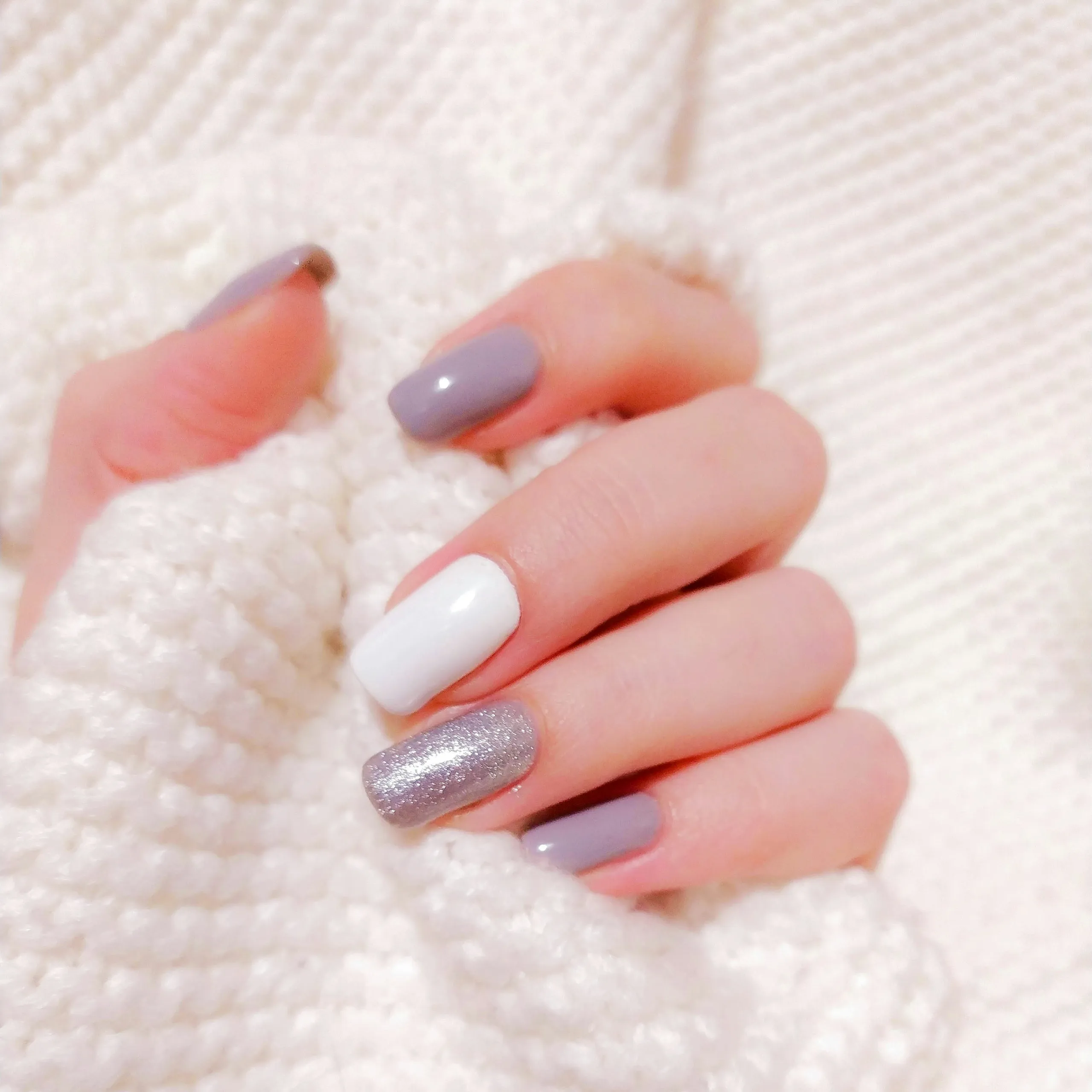 Manicura semipermanente: uñas gris y blanco con detalle de purpurina plateada