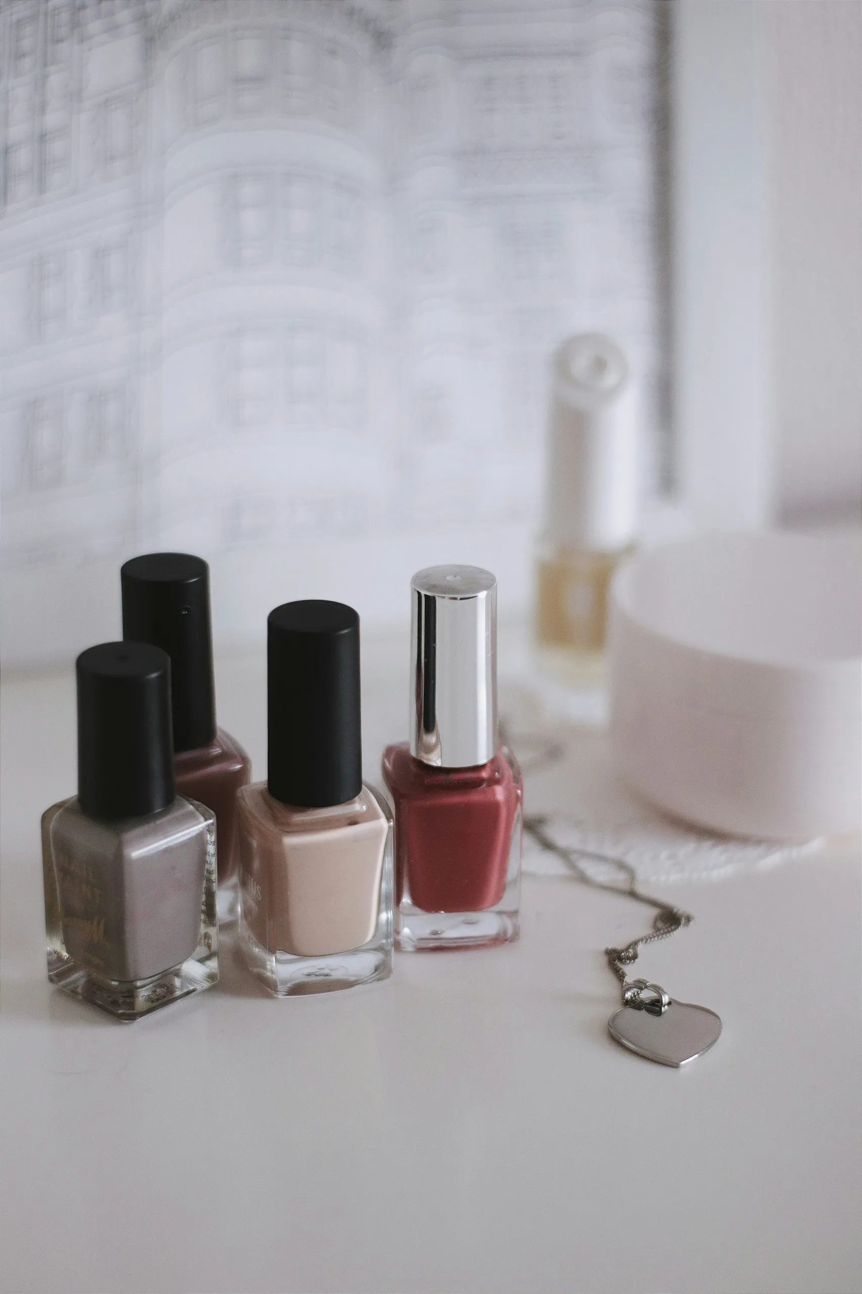 Esmaltes de uñas en tonos beige y rojo sobre una mesa