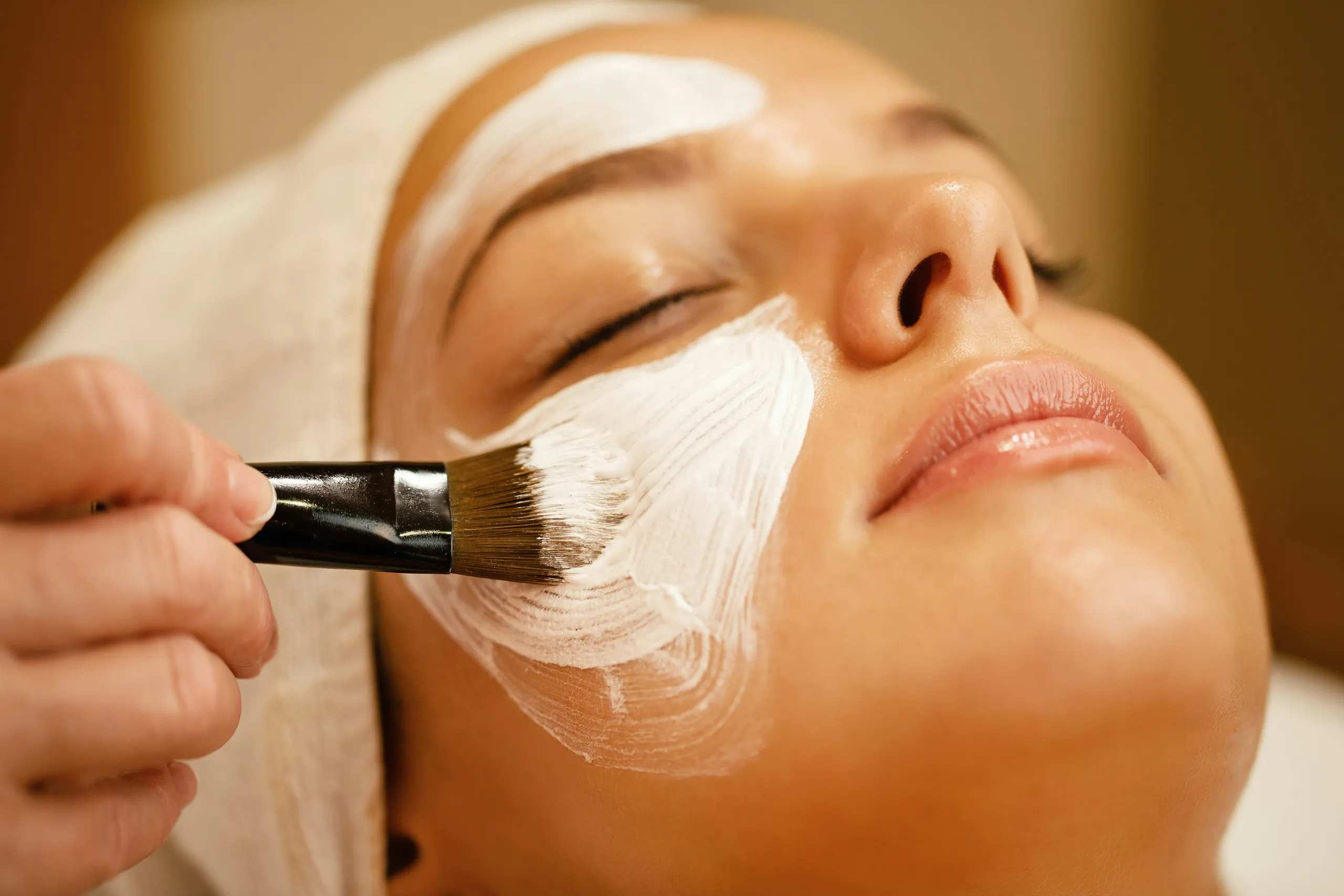 Tratamiento facial: aplicación de mascarilla con pincel en el salón